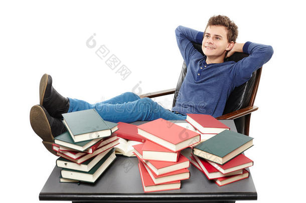 学生在书桌上休息，在成堆的书中做白日梦