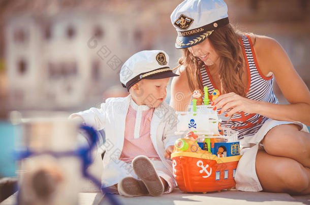 一位母亲和儿子在城市<strong>海边</strong>的码头上<strong>玩耍</strong>的画像，静物照片