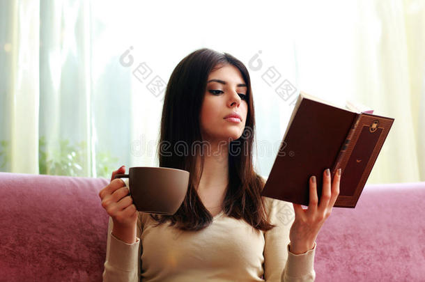 美女<strong>端着</strong>咖啡看书