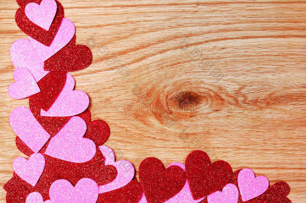 情人节背景。在木头上闪闪发光的红色和粉红色的心