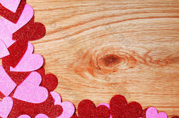 情人节背景。在木头上闪闪发光的红色和粉红色的心