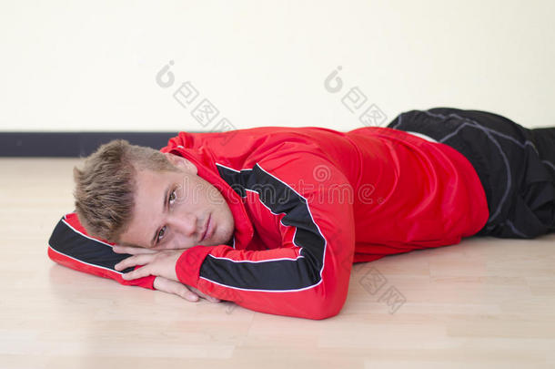 穿着运动服躺在地板上的帅哥