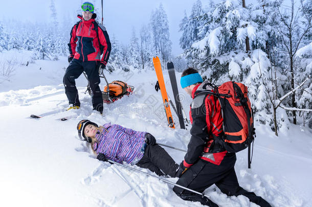 救援滑雪巡逻队帮助受伤的女滑雪者
