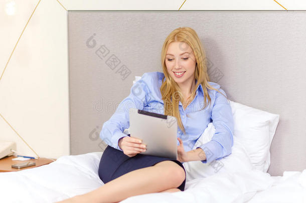酒店客房内配有平板电脑的快乐女商人
