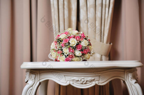 新娘的婚礼花束-婚礼上放在桌上的粉红色、白色玫瑰