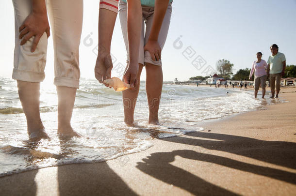 母女俩在沙滩上捡贝壳