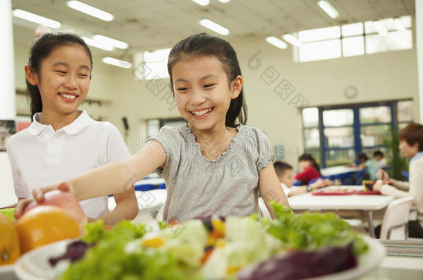 学生在学校食堂伸手取健康食品