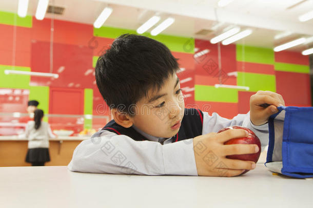 学生在学校食堂检查午餐袋