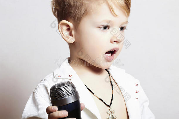 小男孩在唱歌麦克风。儿童在卡拉OK音乐