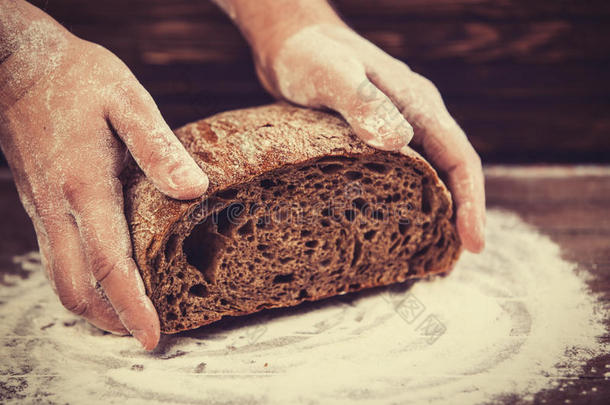 面包师傅的手拿着面包。