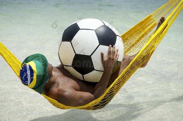 巴西人在沙滩吊床上用足球放松身心