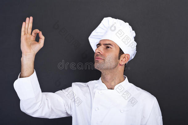 男厨师在灰色背景下亲吻手指