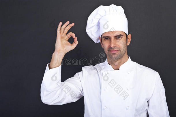 男厨师在灰色背景下亲吻手指