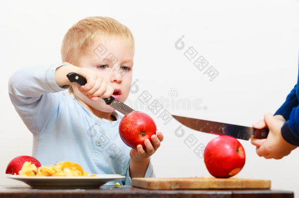 金发男孩小孩学龄前儿童用菜刀<strong>切水果</strong>苹果