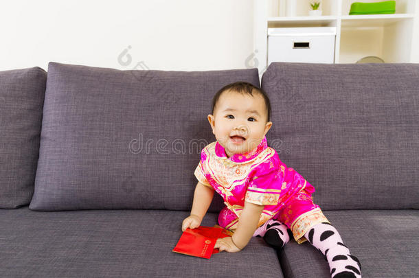 亚洲宝宝拿着中国传统服装的红色口袋