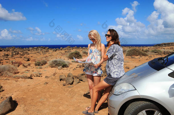 两个有车的年轻女子看<strong>路线图</strong>