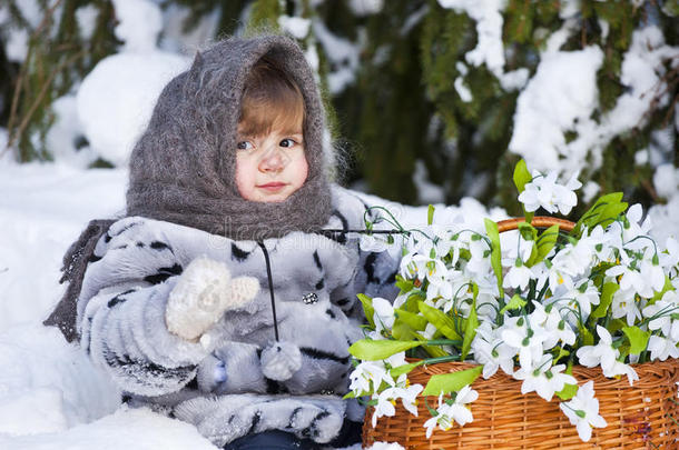 小女孩在冬日的树林里拿着一大筐雪水