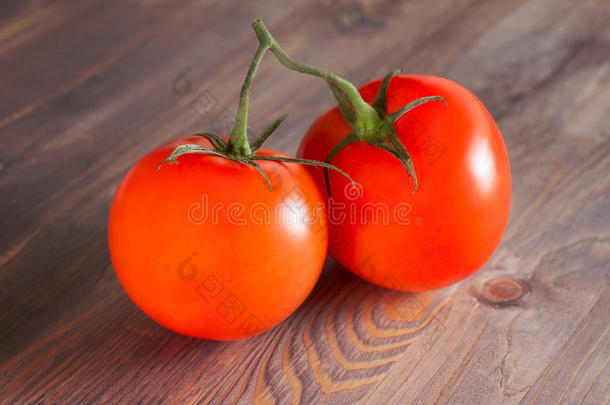 新鲜成熟的西红柿放在树枝上。深色木质背景