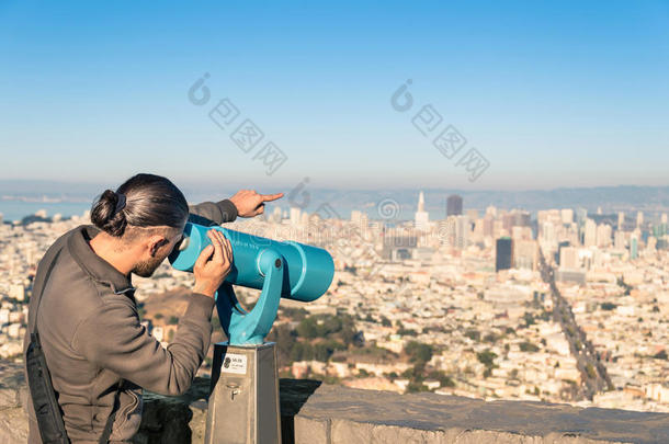 从双峰用双目望远镜观察旧金山市中心的人