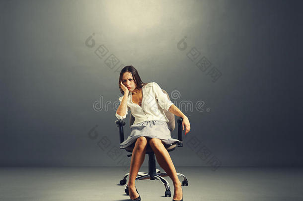 坐在空荡荡的黑屋子里的椅子上的女人