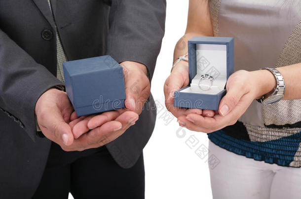 两只手拿着带戒指的盒子。 情人节