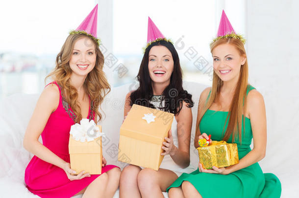 三个戴粉色礼帽带礼盒的微笑女子
