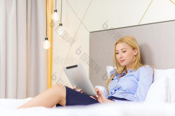酒店客房内配有平板电脑的快乐女商人