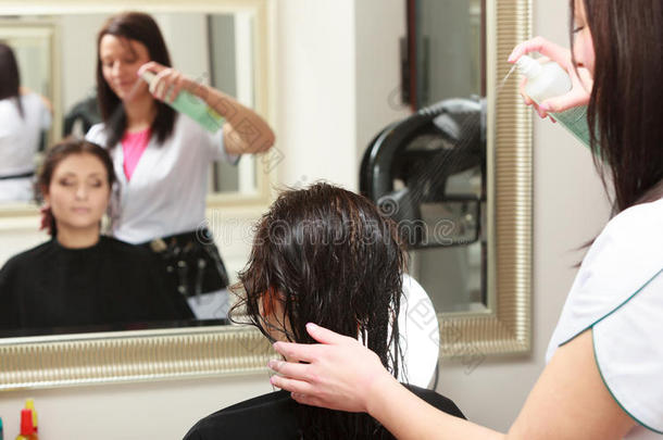 美发师在美发美容院给美发女客户喷头发