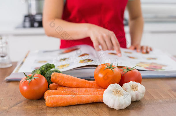 厨房里有<strong>菜谱</strong>和蔬菜的女人的中段