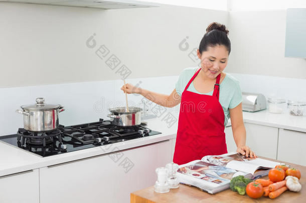 女人看菜谱在厨房做饭