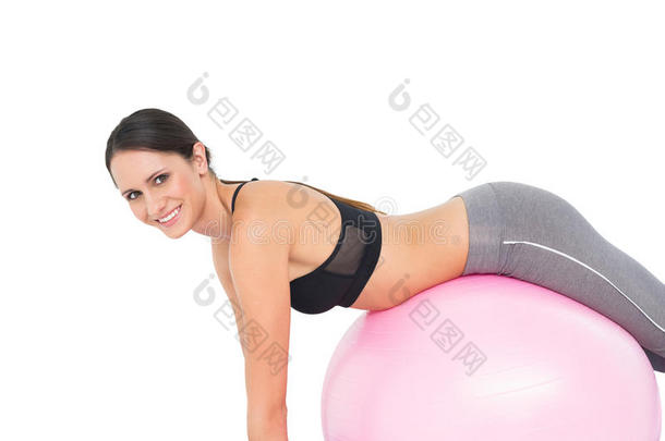 <strong>健美女</strong>子在健身球上伸展的侧视图