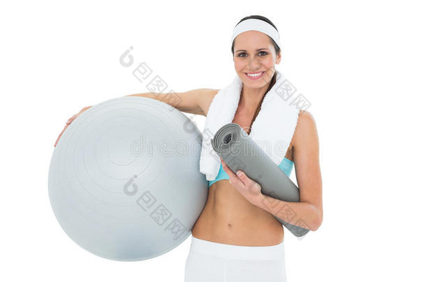 微笑健康的女士手持健身球和健身垫