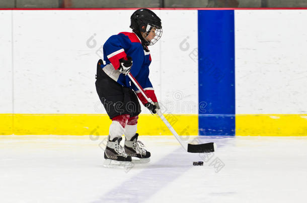 冰球练习场上和冰球一起滑冰的男孩