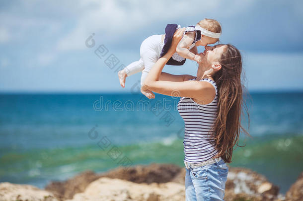 夏日蓝海边嬉戏的妇幼幸福家庭写真