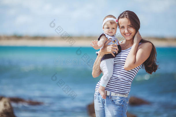 夏日蓝海边嬉戏的妇幼幸福家庭写真