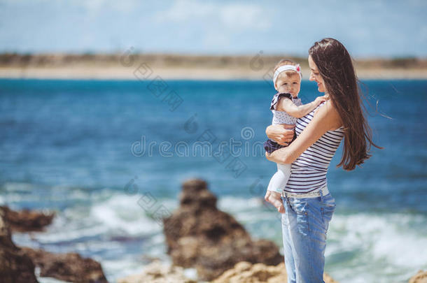 夏日蓝海边嬉戏的妇幼幸福家庭写真