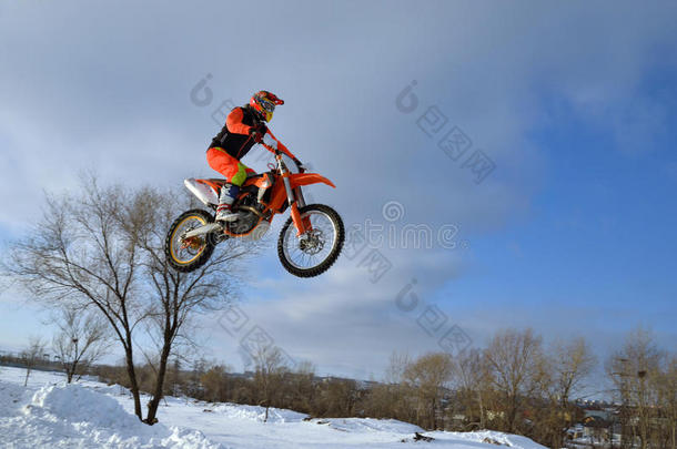 冬季摩托车越野赛，在雪堆上高飞的摩托车赛车手