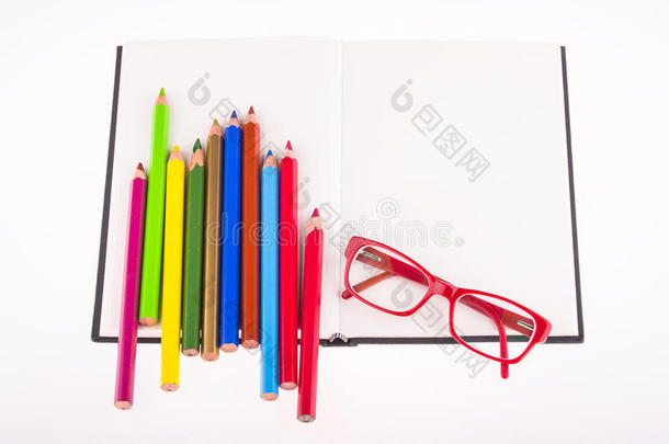 放在笔记本上的红<strong>眼镜</strong>和<strong>彩色</strong>铅笔