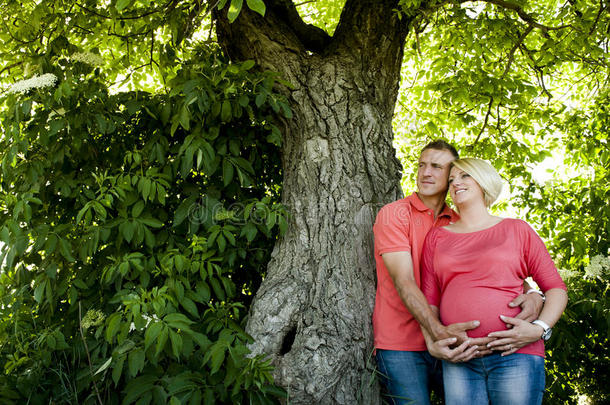 穿着牛仔裤和<strong>粉色</strong>t恤的幸福怀孕夫妇的<strong>画</strong>像