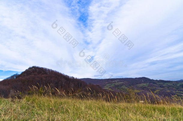 阳光明媚的秋日，几片云彩映照下的莫洛耶山脉景观