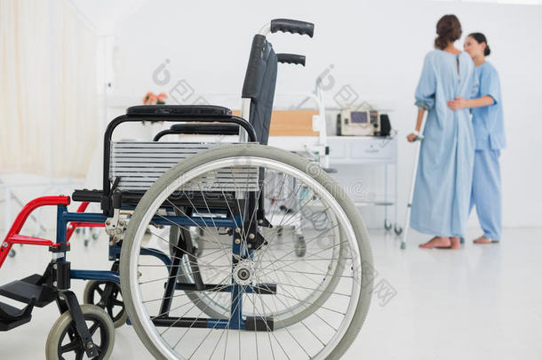医生帮助病人在前面坐轮椅行走