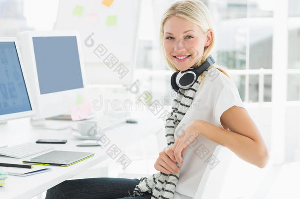 办公室电脑桌旁戴耳机的休闲女士