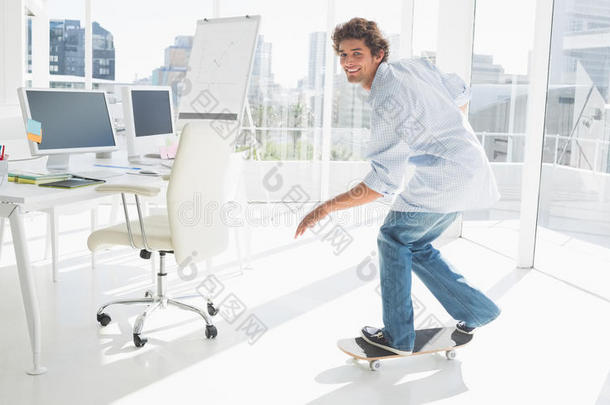 快乐的年轻人在明亮的办公室里玩滑板