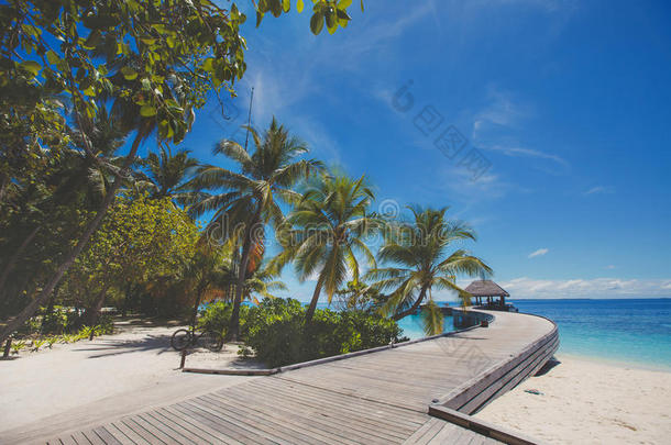 热带岛屿海滩的景观，完美的天空、棕榈树、传统建筑