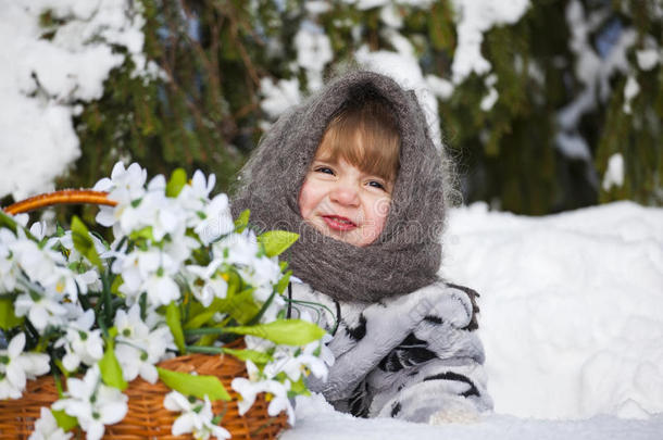 小女孩在冬日的树林里拿着一大筐雪水