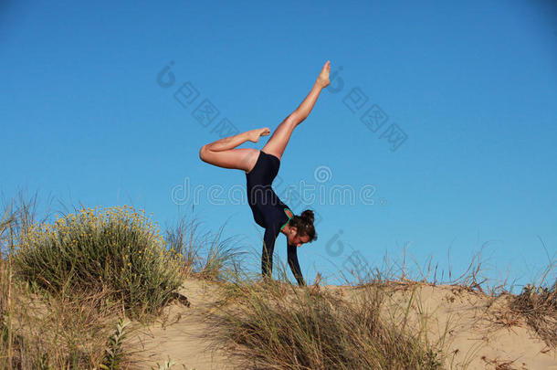 在海滩上做杂技<strong>倒立</strong>的体操运动员