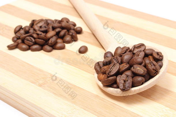 一堆咖啡放在木勺上。木质背景
