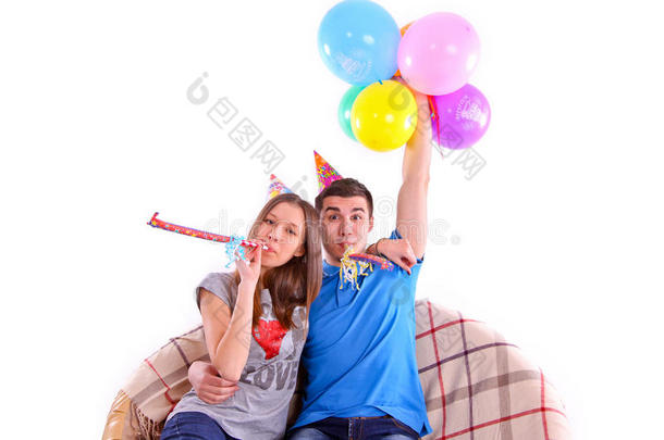 一对戴着帽子和<strong>气球</strong>的夫妇<strong>坐</strong>在沙发上
