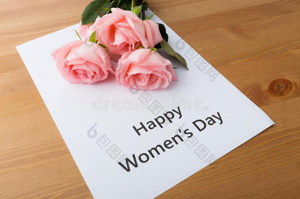 一束粉红色玫瑰，上面写着“妇女节快乐”的信息