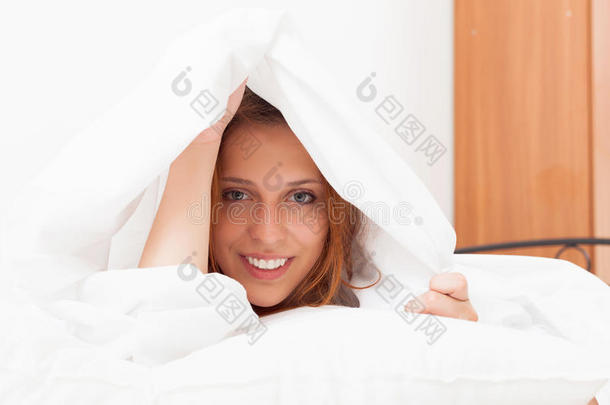穿衬衫的女孩在家里温暖的床上被白色床单<strong>惊醒</strong>